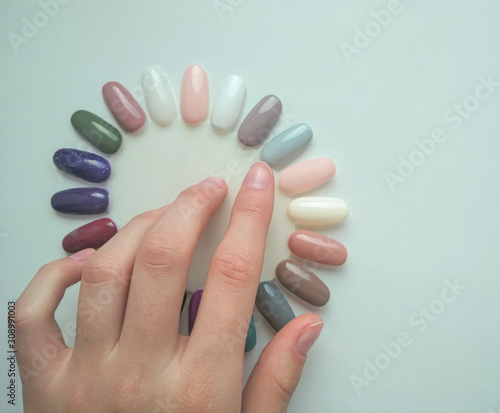 Tips for manicure in the form of chamomile. Palette of pastel colors. The customer chooses the color. Hand shows the color.