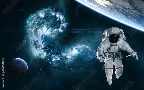 Fototapeta Naklejka Na Ścianę i Meble -  The collapse of galaxies. Astronaut, planets in deep space against background of collision of galaxies in blue tones. Science fiction. Elements of this image furnished by NASA