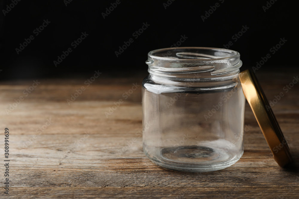 Empty glass jar on wooden table, space for text Empty glass jar on wooden table, space for text