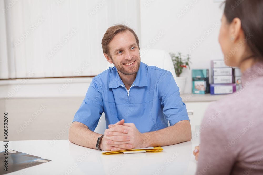 Cheerful mature male doctor talking to a patient Cheerful mature male doctor talking to a patient