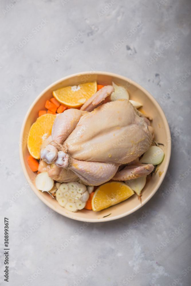 Whole raw chicken in pan with orange, spice . Ready to cook. Cooking background. Copy space Whole raw chicken in pan with orange, spice . Ready to cook. Cooking background. Copy space