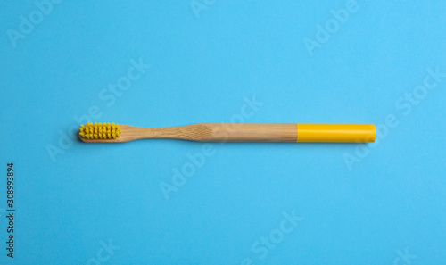 Toothbrush made of bamboo on light blue background  top view