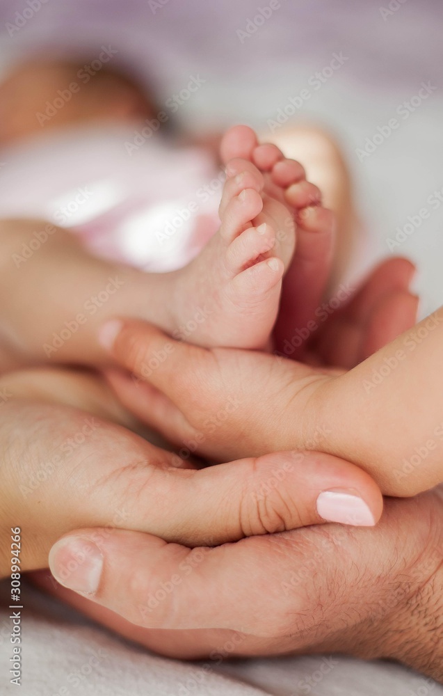 Closeup mother holds little baby girls legs in her arms. Motherhood. Closeup mother holds little baby girls legs in her arms. Motherhood.