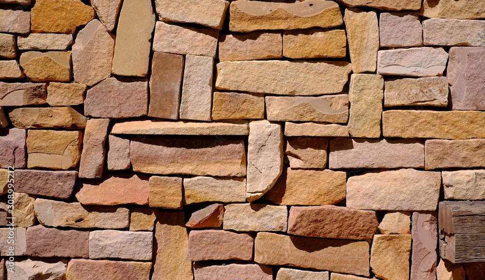 Obraz premium Stone walls made of small pieces of stone arranged background