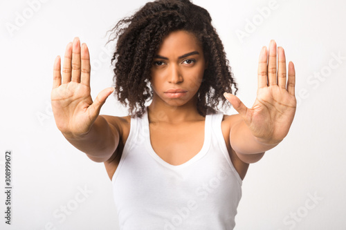 Serious black girl showing stop sign with two hands