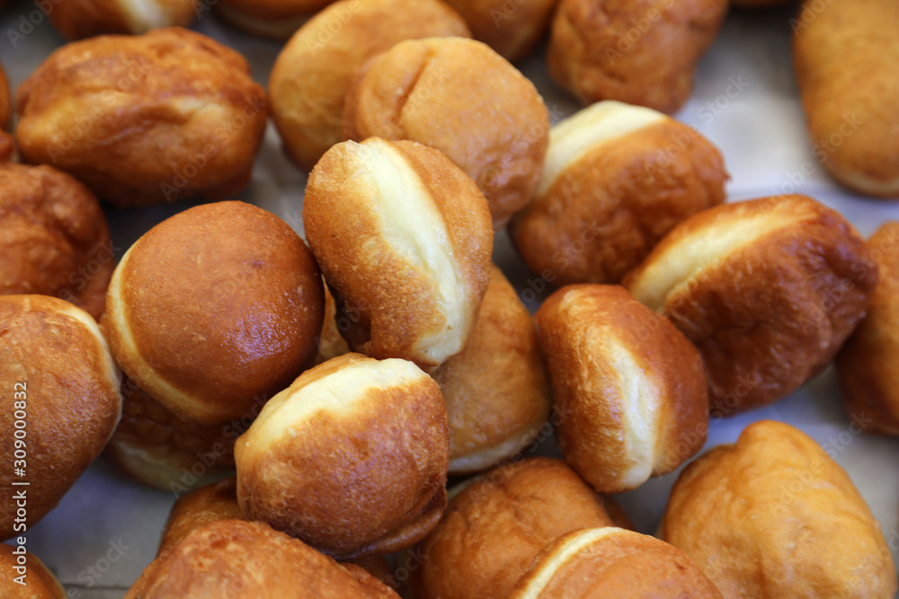 Obraz premium Crusty carnival donuts fried in oil on new years event