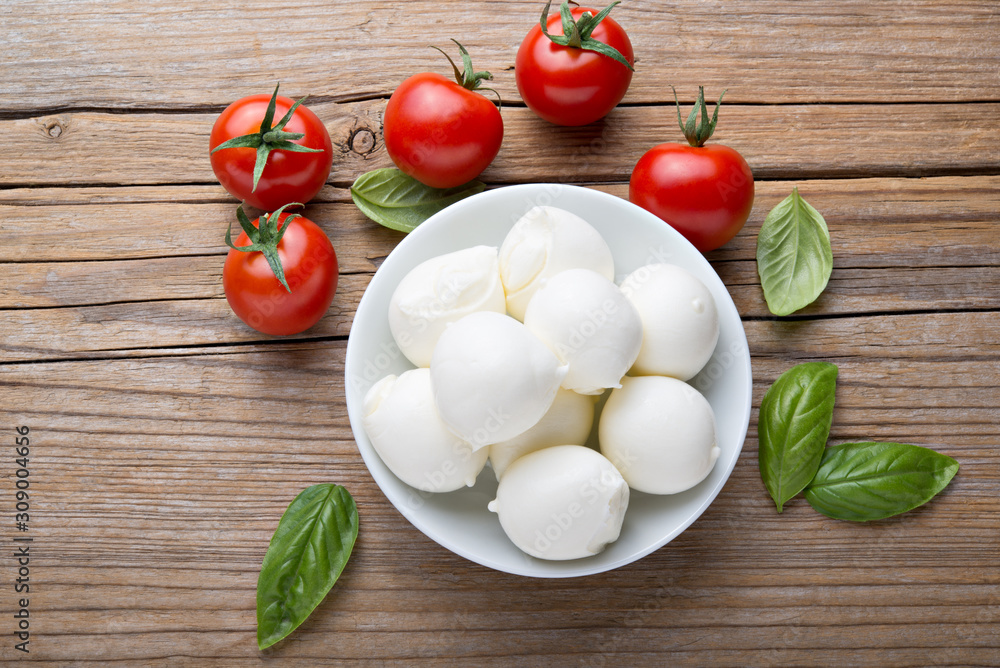 Small mozzarella balls, cherry tomatoes and basil. Top view. Small mozzarella balls, cherry tomatoes and basil. Top view.