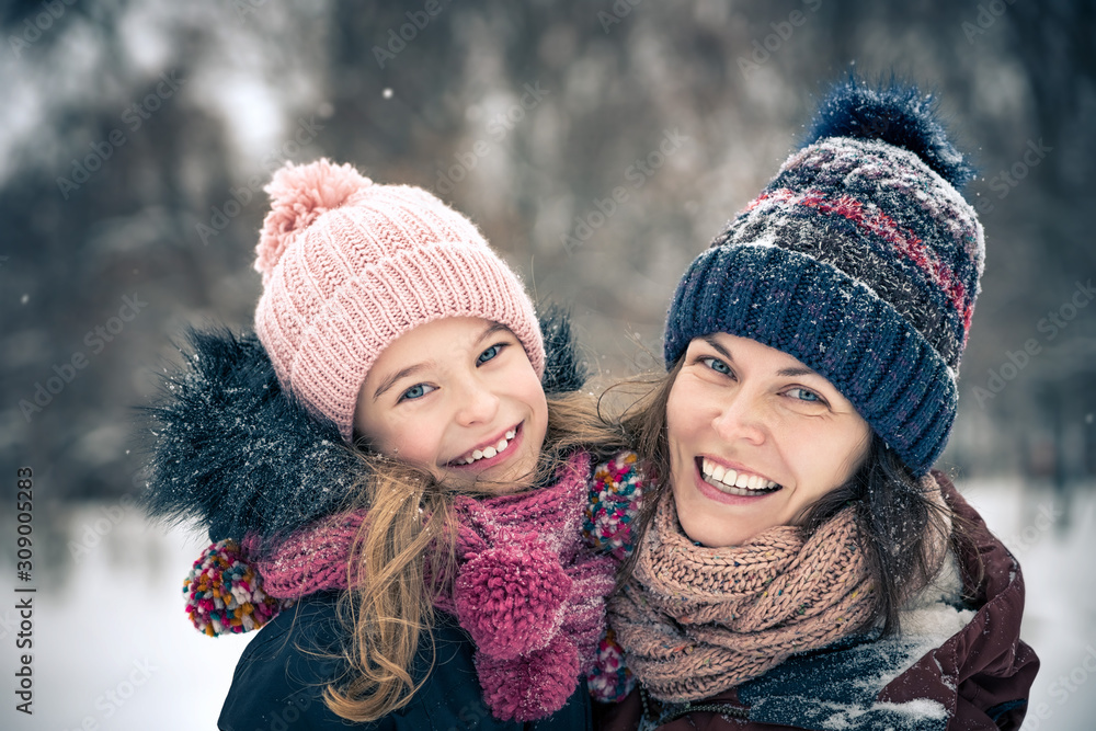 Little girl and her mother playing outdoors at winter day. Active winter holydays concept. Little girl and her mother playing outdoors at winter day. Active winter holydays concept.