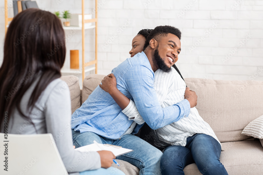 Obraz premium Married couple embracing after successful therapy at counsellor's office