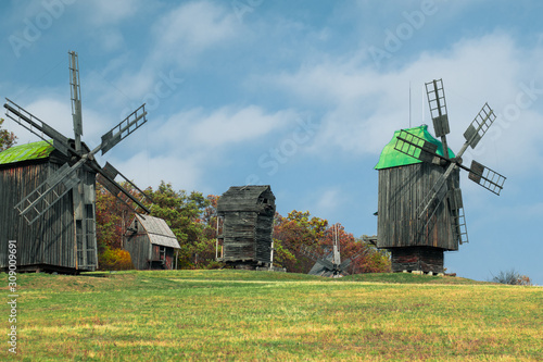 Windmills in the field. Three wooden windmills on an old farm