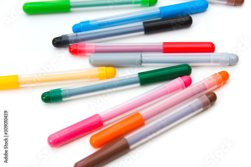 Colorful markers scattered on a white background. Art and education. Isolated. Side view Selective focus.