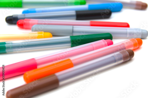 Colorful markers scattered on a white background. Art and education. Isolated. Side view Selective focus.