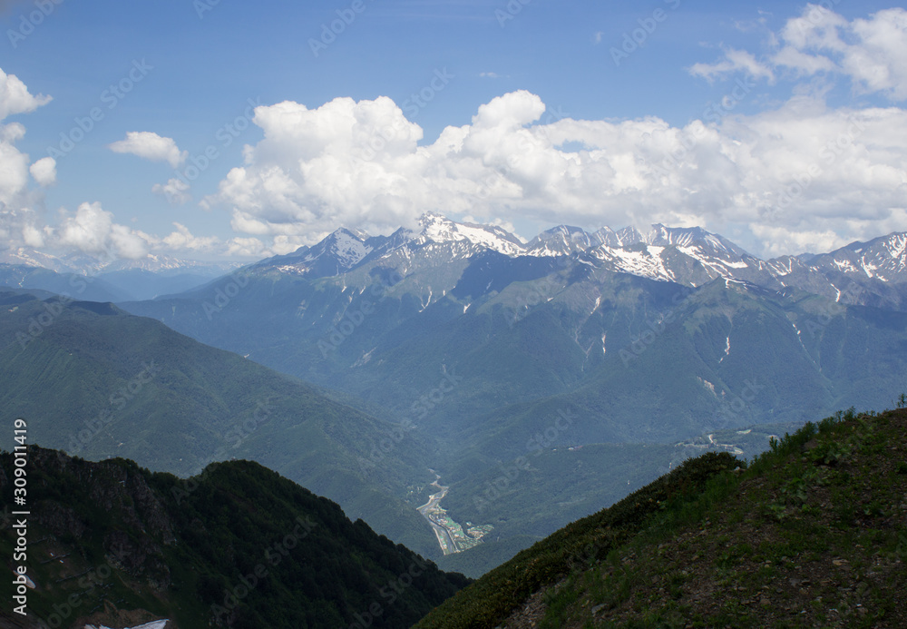 View from one of the peaks of the Caucasus mountain range to the mountain range and the valley below