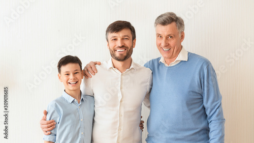 Man Hugging Little Son And Senior Father Standing, White Background
