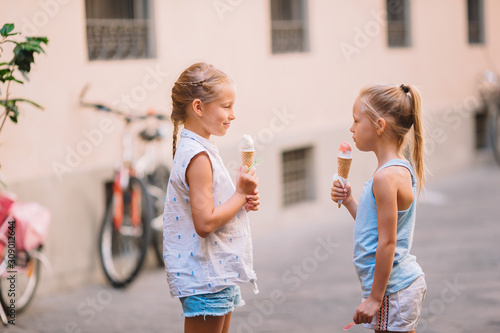 Canvas Print Adorable little girls eating ice-cream outdoors at summer.
