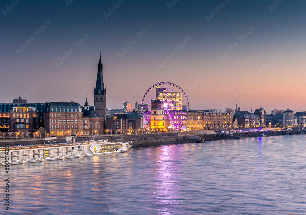 Old town Rhine front in Düsseldorf with river cruise ship and ferris wheel 