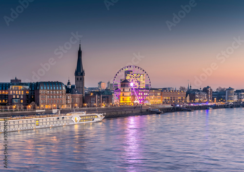 Old town Rhine front in Düsseldorf with river cruise ship and ferris wheel 