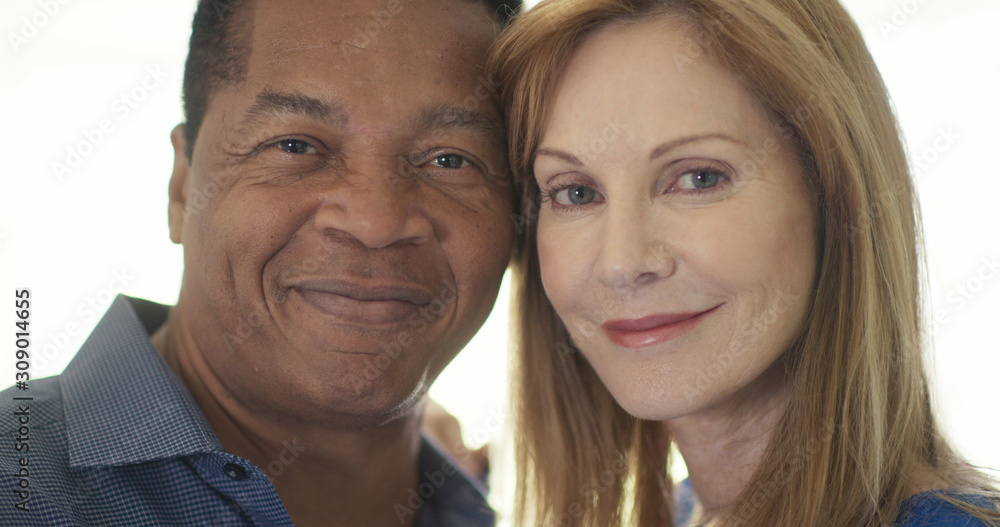 Close up portrait of married couple smiling by window Close up portrait of married couple smiling by window