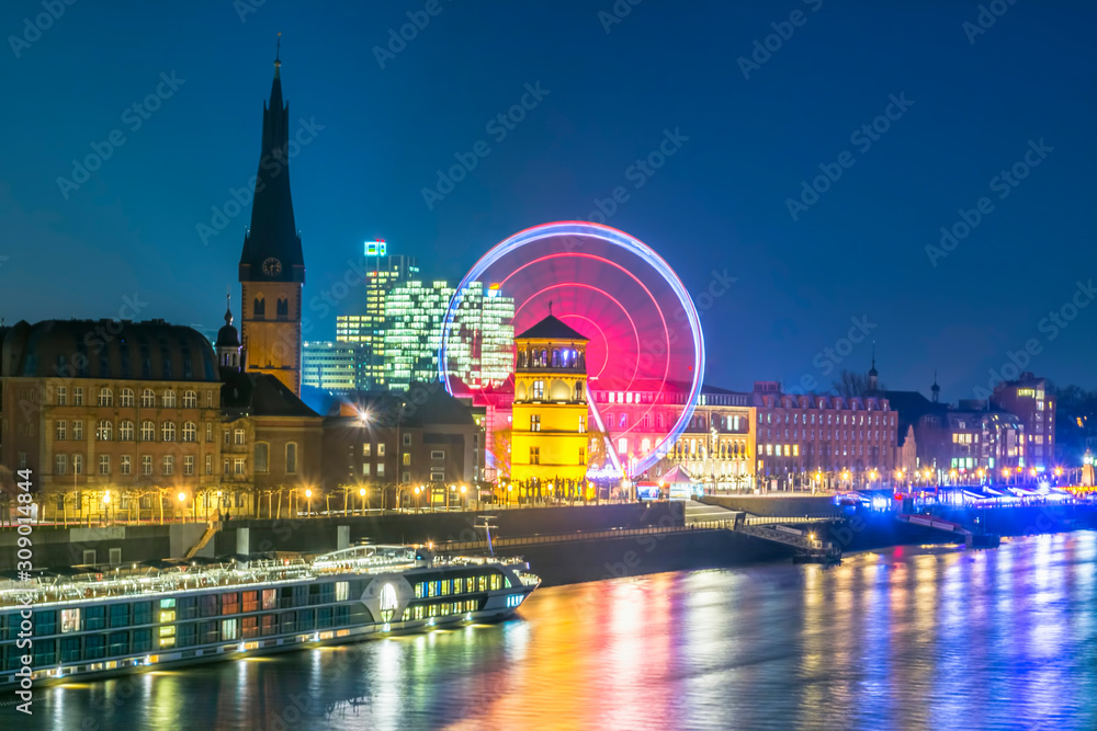 Obraz premium Düsseldorf rhine river front and old town with Schlossturm museum and ferris wheel during night