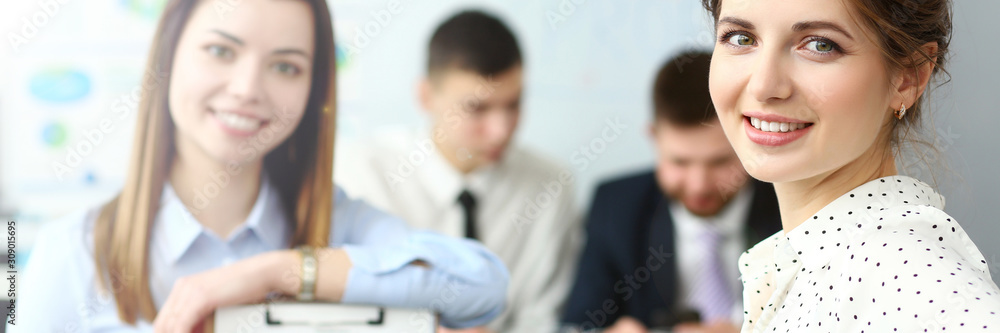Young beautiful smiling clerk in office looking in camera Young beautiful smiling clerk in office looking in camera