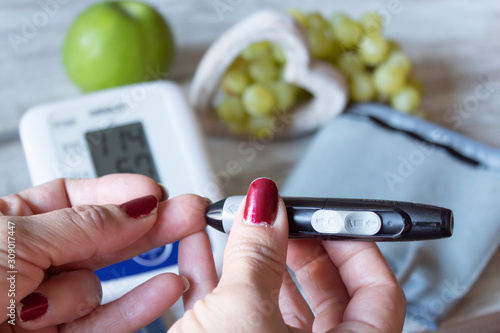 Woman checking her blood glucose with glucometer