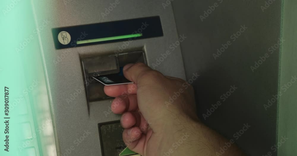 Man taking credit card out of cash machine outdoors, closeup Man taking credit card out of cash machine outdoors, closeup