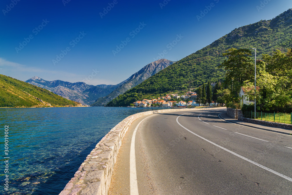 Sunny morning view of Kotor bay and coastal road near Tivat, Montenegro.
