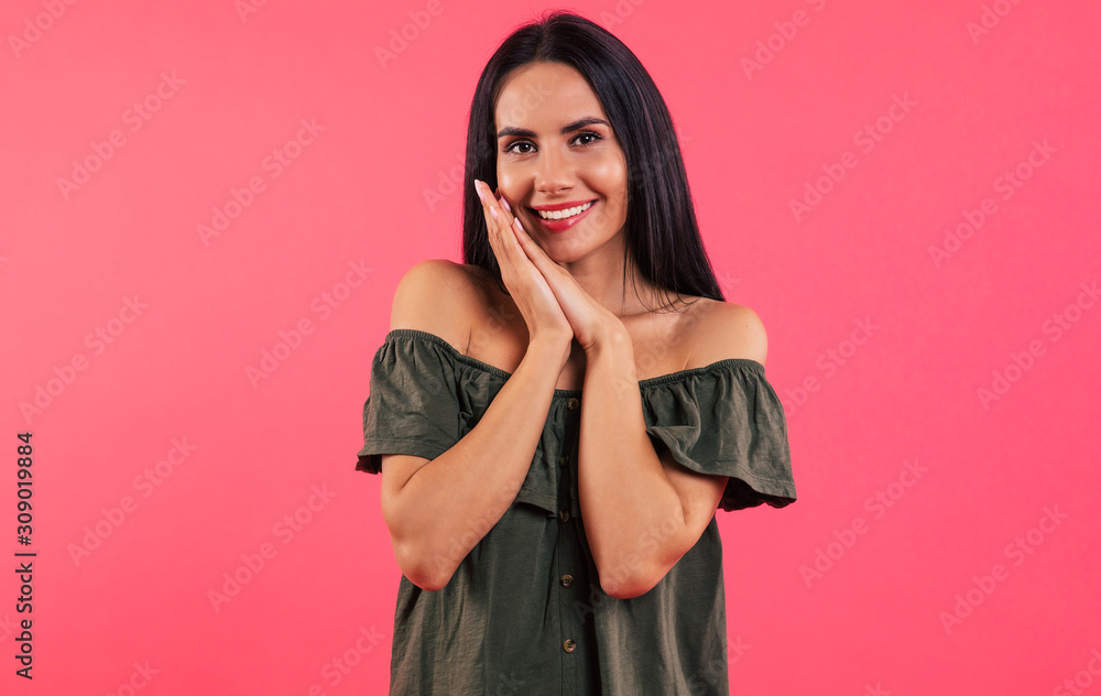 Lovely look. Close-up photo of a cute girl in a dark green dress, who is looking in the camera and smiling broadly, pressing her palms together near her chin. Lovely look. Close-up photo of a cute girl in a dark green dress, who is looking in the camera and smiling broadly, pressing her palms together near her chin.