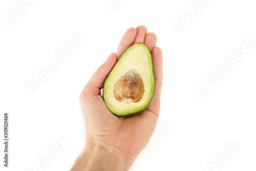 cropped view of man holding avocado half with seed isolated on white