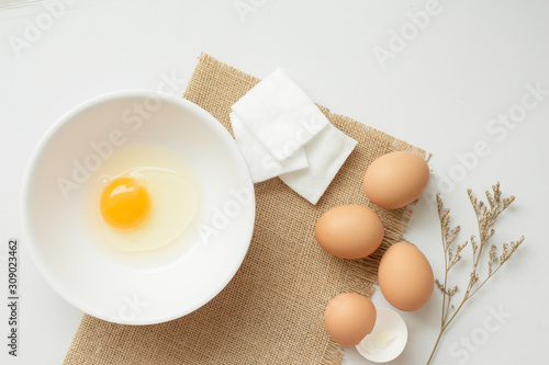 Flat lay of egg white and cotton pad, facial mask for acne skin.