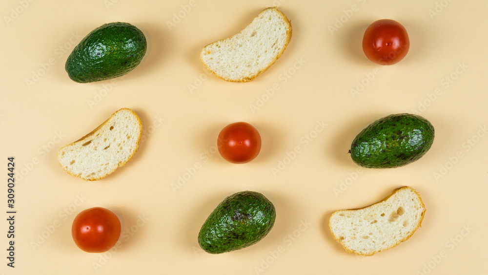 Flat lay of ripe avocado on yellow background, tomato and bread. Cooking and eating vegan sandwich. Flat lay of ripe avocado on yellow background, tomato and bread. Cooking and eating vegan sandwich.