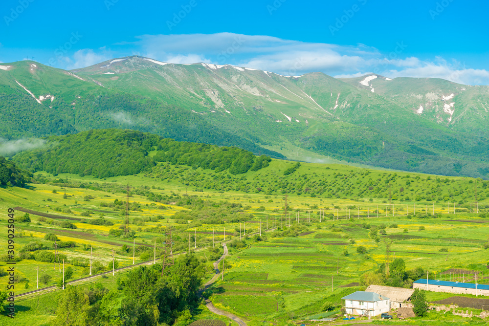 High picturesque mountains with snow on top and green lush meadows beautiful landscape of Armenia from a height