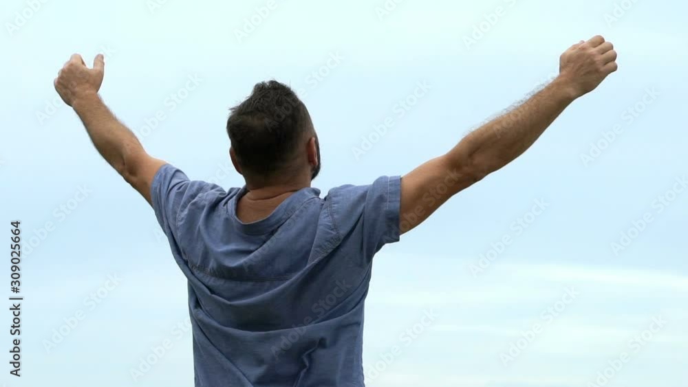 Excited, successful man rising arms to the sky, super slow motion Excited, successful man rising arms to the sky, super slow motion