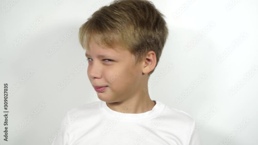 Closeup view portrait of white caucasian kid raising his one brow up as if asking something than shaking his head in rejection. Real time 4k video footage. Closeup view portrait of white caucasian kid raising his one brow up as if asking something than shaking his head in rejection. Real time 4k video footage.