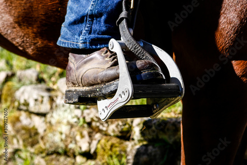 Détail d'un pied dans un étrier de selle western pour la randonnée équestre