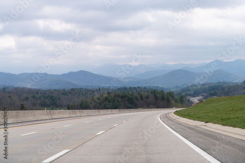 Smoky Mountains silhouette near Asheville, North Carolina near Tennessee border with cloudy sky and forest trees on steep i26 highway road