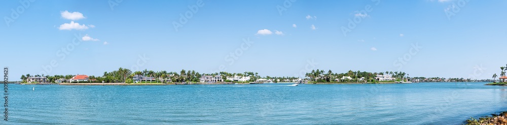 Naples, Florida Nelson's Walk houses buildings with water on Dollar bay palm trees, blue sky in residential community vacation homes panorama view