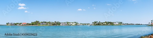 Naples, Florida Nelson's Walk houses buildings with water on Dollar bay palm trees, blue sky in residential community vacation homes panorama view © Andriy Blokhin