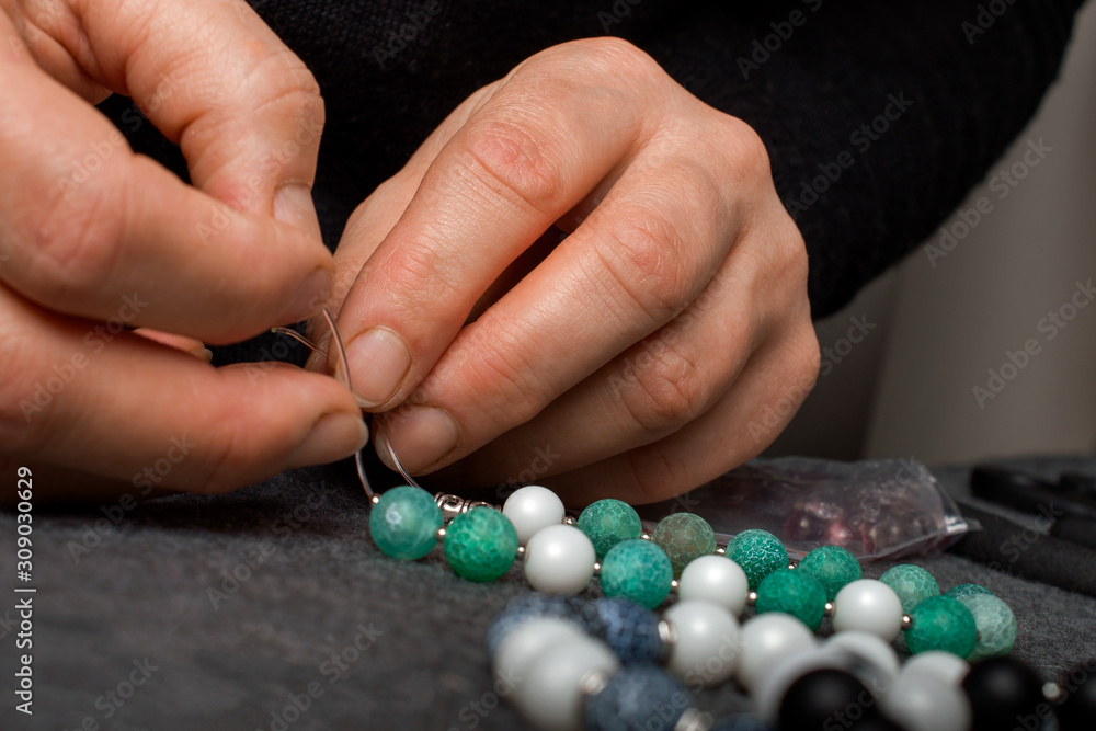 Woman making homemade beaded  bracelet, closeup.