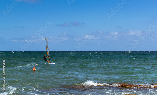 surfista in mare vicino agli scogli