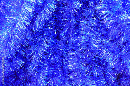 Christmas tinsel of the bright classic blue color with silver sparkle as a festive bright background