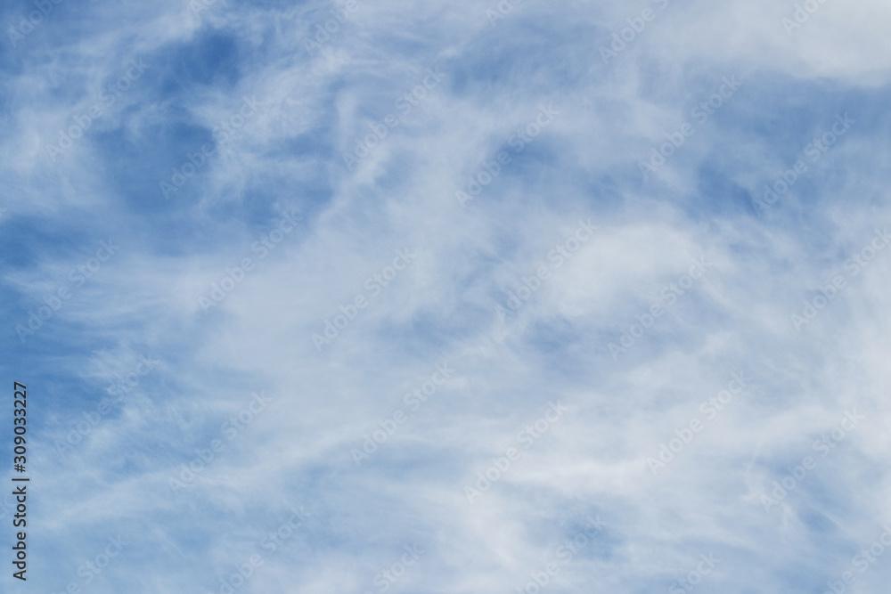 Light blue sky with white clouds of uncertain shape_