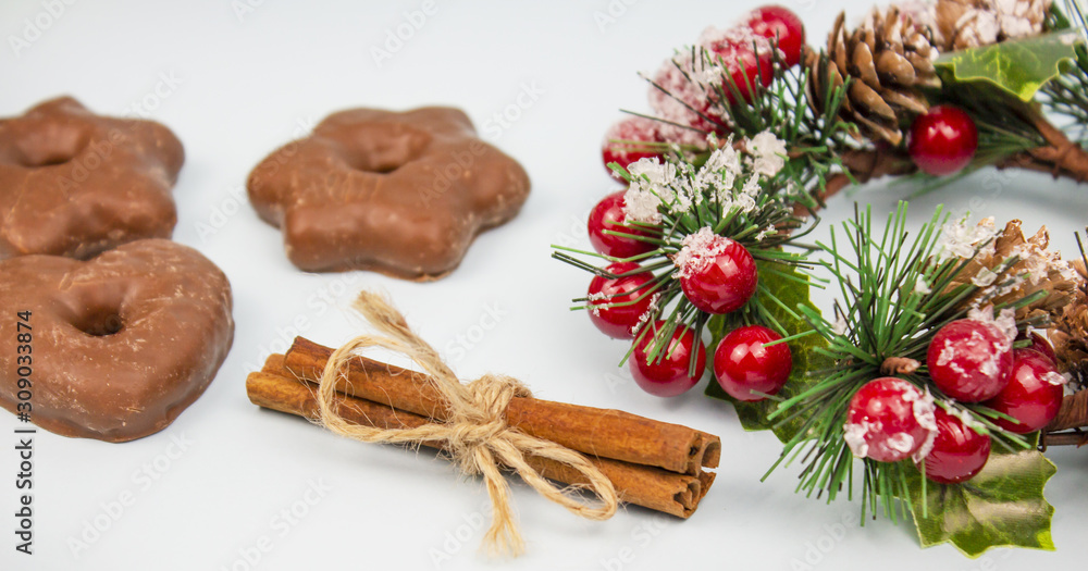 Christmas composition with chocolate gingerbread cookies and cinnamon, Christmas wreath and chopsticks on a light background. Cinnamon. banner. place for text