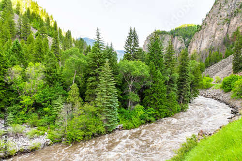 Road highway 133 in Redstone, Colorado during summer with raging crystal river and green trees wide angle landscape high angle view