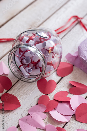 Fototapeta Naklejka Na Ścianę i Meble -  Valentine's day concept. Opened Date Jar with desires and paper hearts on wood