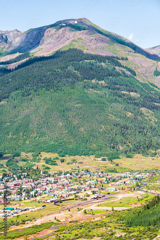 High angle aerial vertical view of Silverton, Colorado small town from overlook during sunny day in summer with forest trees mountain peak