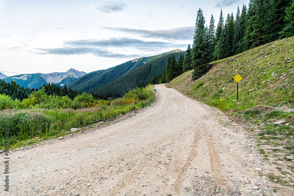 Fototapeta premium Wide angle view of green alpine mountains with dirt road leading to Ophir pass near Columbine lake trail in Silverton, Colorado in 2019 summer morning