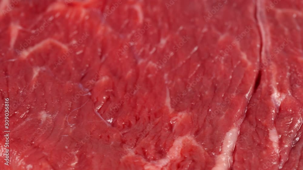 Fresh angus beef steak slow rotating, low angle. Uncooked meat surface, shallow DOF Fresh angus beef steak slow rotating, low angle. Uncooked meat surface, shallow DOF