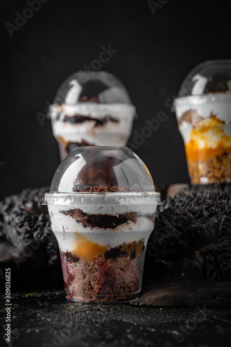 Chia seed dessert, granola with yogurt, jam and chocolate. Healthy breakfast. Take and go food. Delivery. A plastic cup.