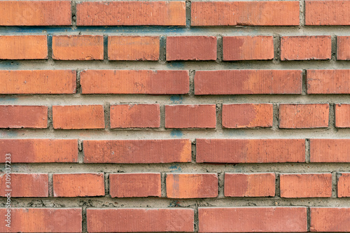 Wall texture of modern brown rough brick. Cross brickwork. Grunge surface background. Vintage orange brickwall.